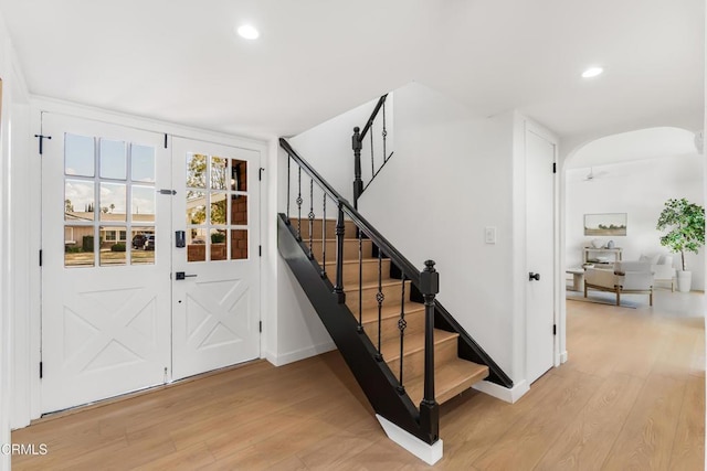 staircase with ceiling fan and hardwood / wood-style flooring