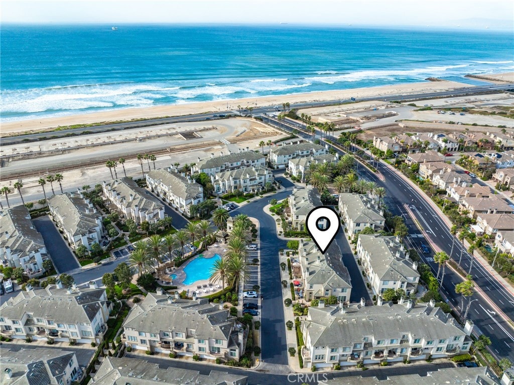 birds eye view of property featuring a water view and a beach view