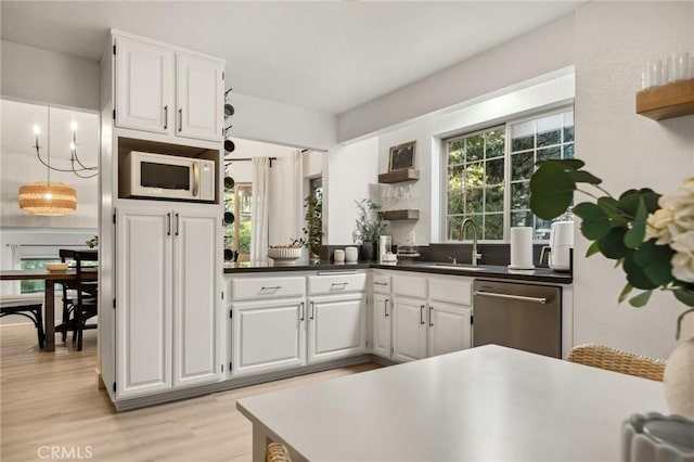 kitchen featuring white cabinetry, light hardwood / wood-style floors, sink, a chandelier, and stainless steel dishwasher