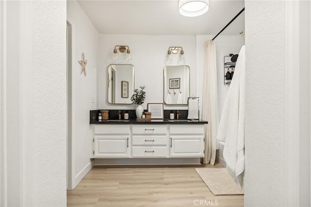 bathroom with wood-type flooring, vanity, and a shower with curtain