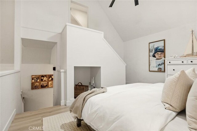 bedroom with light wood-type flooring, ceiling fan, and high vaulted ceiling