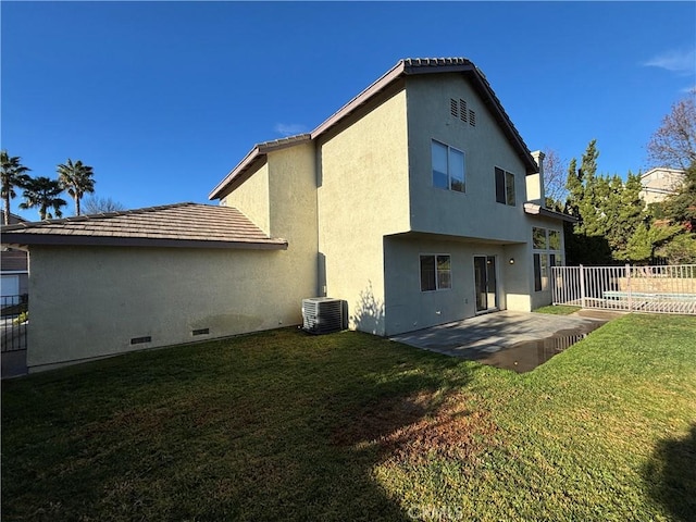 back of house featuring cooling unit, a patio area, and a yard