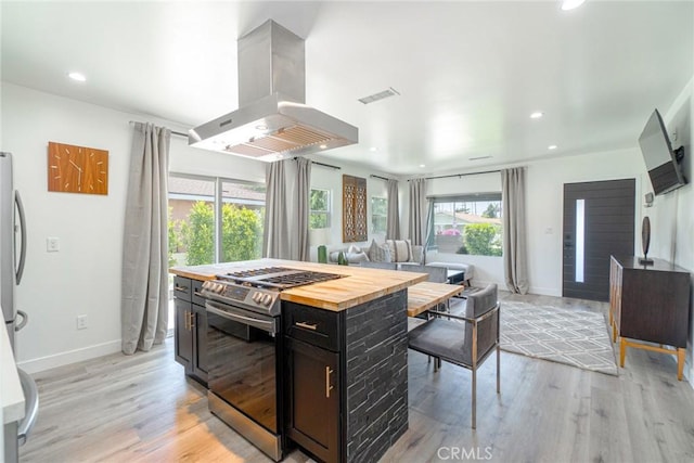 kitchen with plenty of natural light, appliances with stainless steel finishes, island range hood, and light wood-type flooring