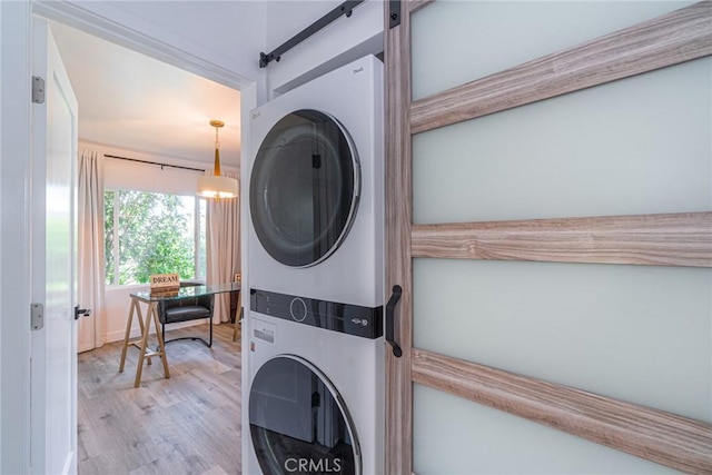 washroom featuring stacked washer / drying machine and light wood-type flooring