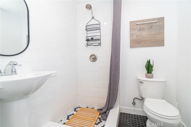 bathroom featuring toilet, tile patterned floors, and walk in shower