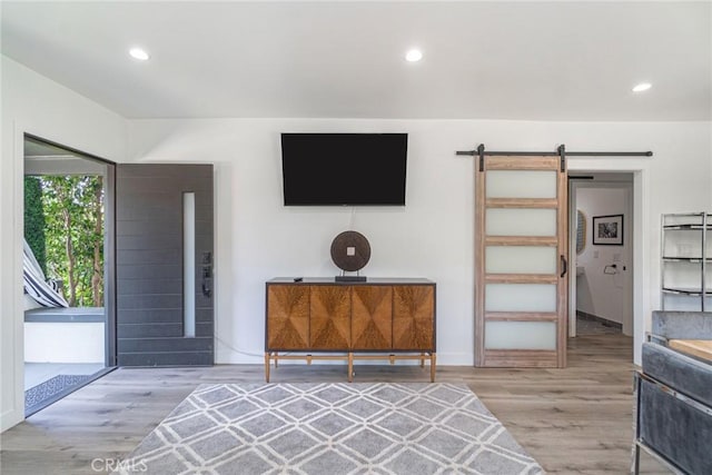 interior space with a barn door and light hardwood / wood-style flooring