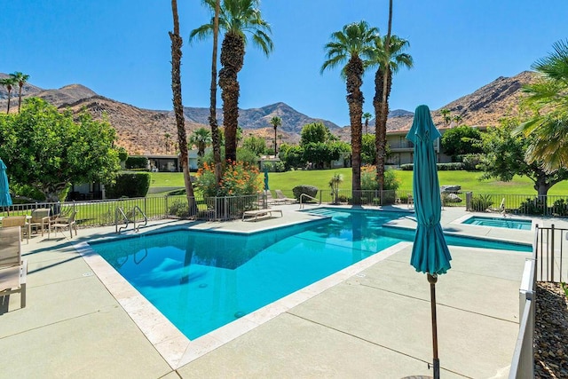 view of swimming pool featuring a mountain view, a yard, and a patio