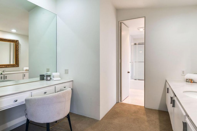 bathroom featuring a shower with shower door and vanity