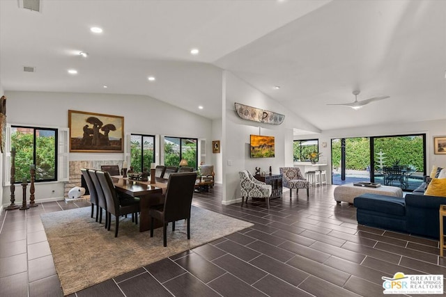 dining room with ceiling fan, a fireplace, and lofted ceiling