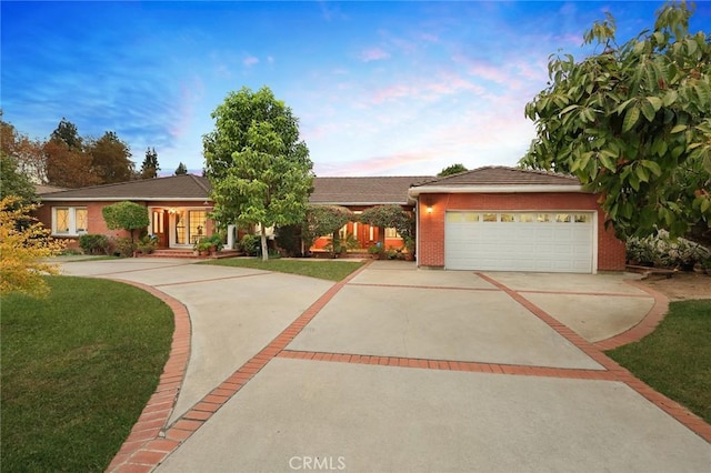 single story home with a garage and a lawn