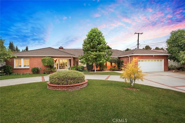 ranch-style home with a garage and a lawn