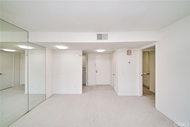 unfurnished room with light colored carpet