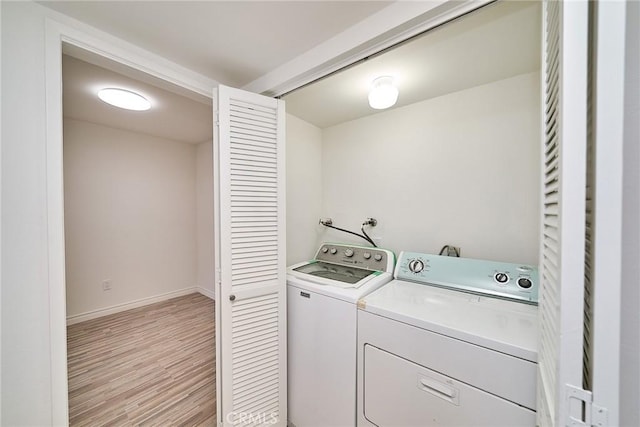 laundry area with light wood-type flooring and washer and dryer