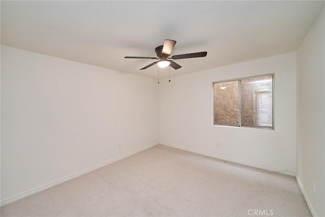 spare room featuring ceiling fan and light colored carpet