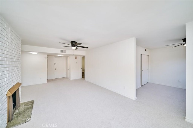 unfurnished living room featuring ceiling fan, light carpet, and a fireplace