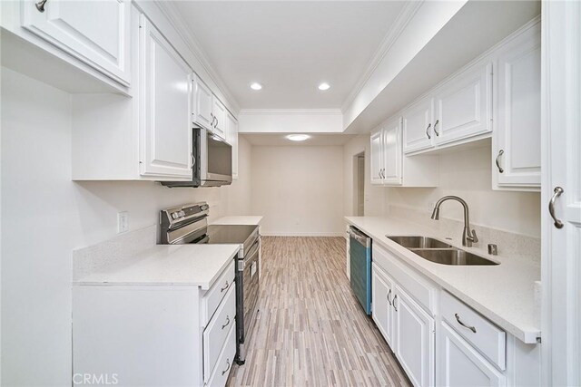 kitchen with white cabinetry, stainless steel appliances, sink, light hardwood / wood-style flooring, and crown molding