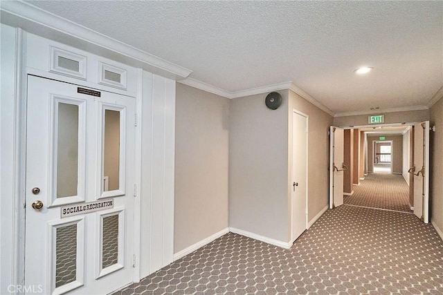 hall featuring dark carpet, crown molding, and a textured ceiling