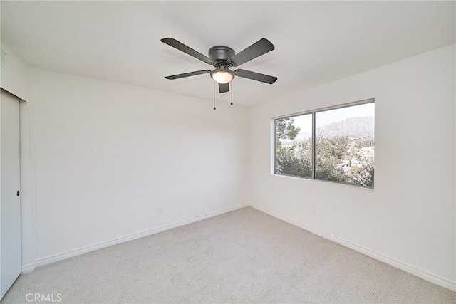 carpeted empty room with a mountain view and ceiling fan