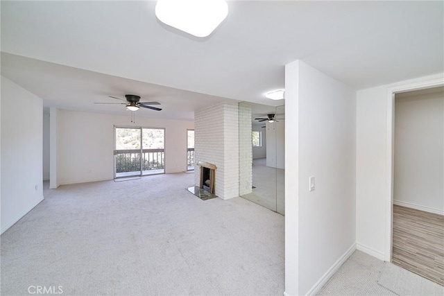 unfurnished living room with light carpet, a fireplace, and ceiling fan