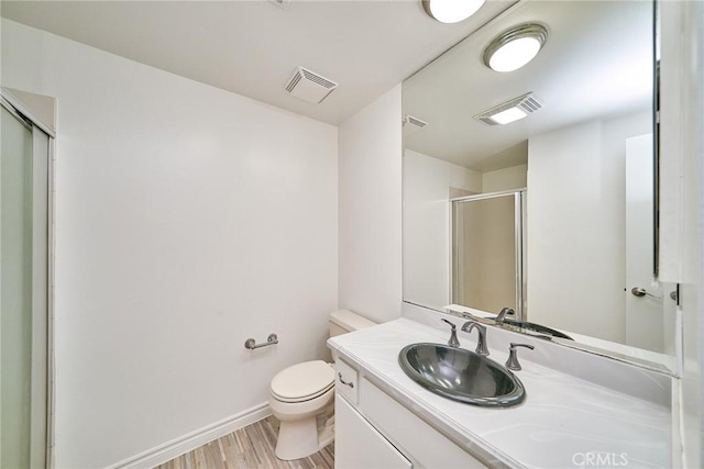 bathroom with vanity, toilet, walk in shower, and wood-type flooring