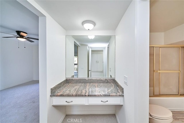 full bathroom featuring vanity, ceiling fan, enclosed tub / shower combo, and toilet