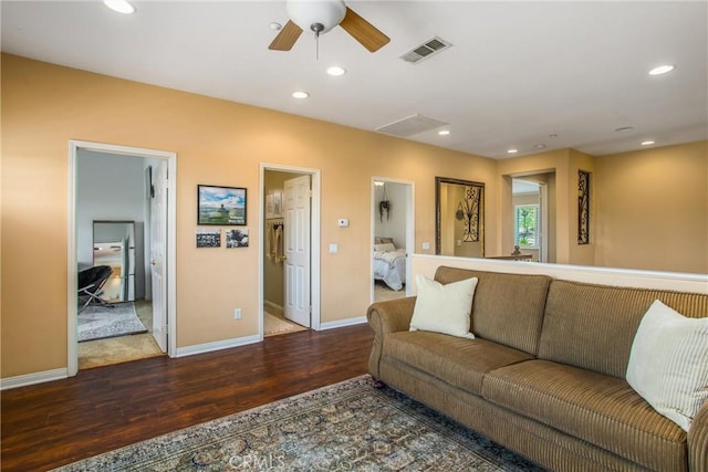 living room with ceiling fan and dark hardwood / wood-style flooring