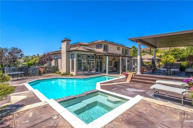 view of pool with a patio area and an in ground hot tub