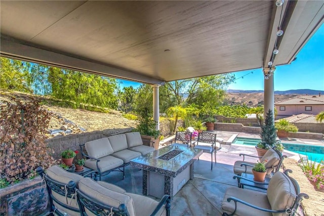 view of patio / terrace featuring a fenced in pool and an outdoor living space with a fire pit