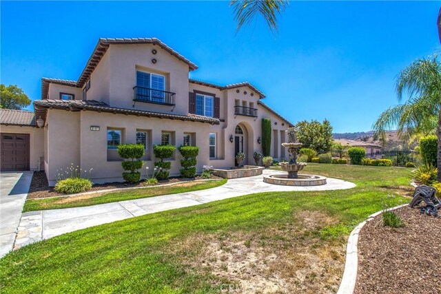 mediterranean / spanish-style home featuring a front yard