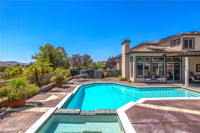 view of pool with an in ground hot tub and a patio