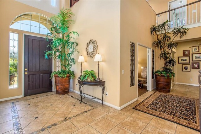 tiled entryway featuring a towering ceiling