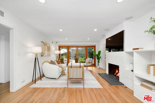 living room with a fireplace and light hardwood / wood-style flooring