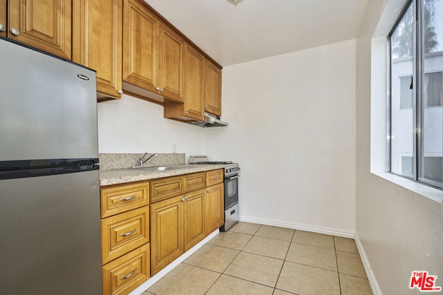 kitchen featuring light tile patterned floors, extractor fan, stainless steel appliances, light stone countertops, and sink