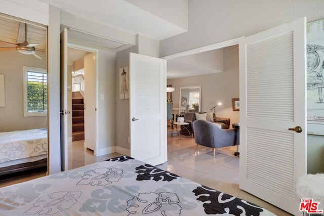 bedroom featuring ceiling fan, ensuite bath, and light tile patterned flooring