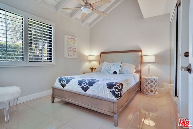 bedroom featuring ceiling fan, vaulted ceiling with beams, a closet, and tile patterned floors