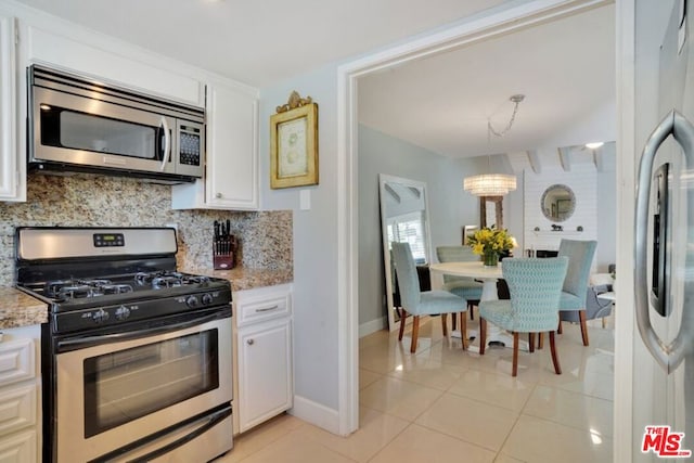 kitchen with white cabinetry, appliances with stainless steel finishes, decorative backsplash, decorative light fixtures, and light tile patterned flooring