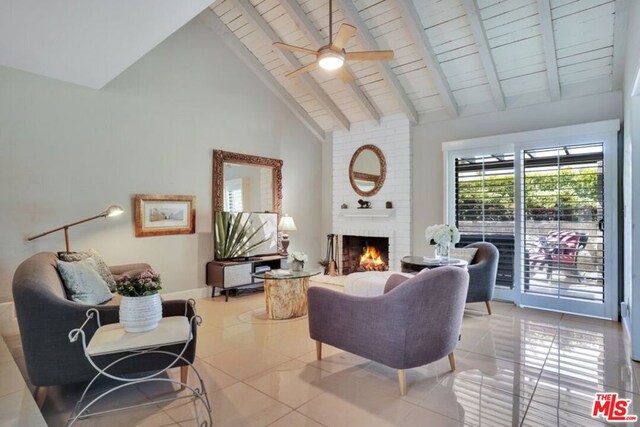 living room with light tile patterned floors, a brick fireplace, ceiling fan, high vaulted ceiling, and beam ceiling