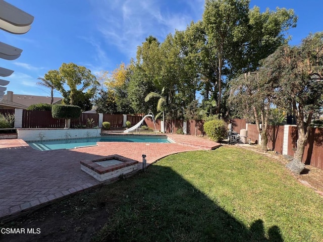 view of pool featuring a patio area, a yard, and a water slide