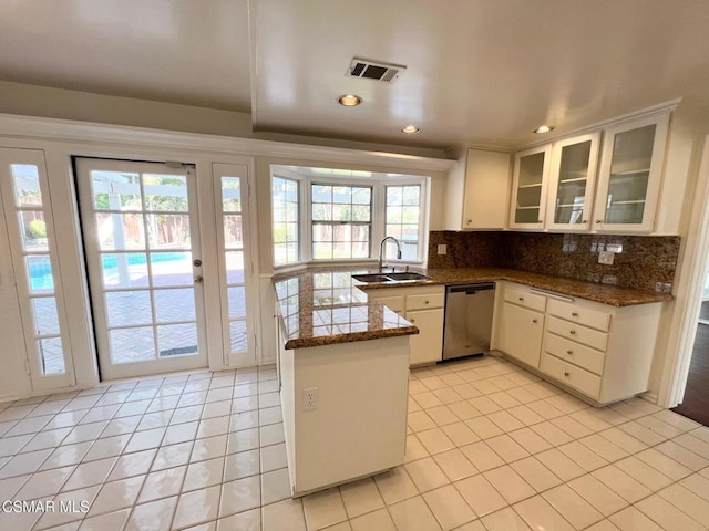 kitchen featuring light tile patterned floors, kitchen peninsula, dishwasher, and sink