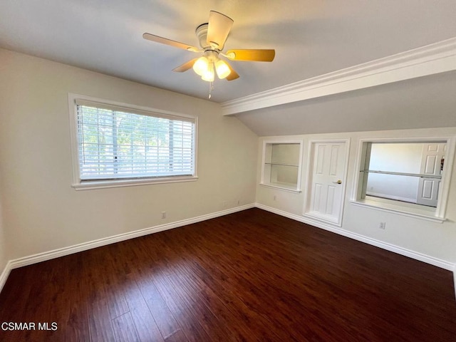 empty room with ceiling fan, lofted ceiling, built in features, and dark hardwood / wood-style floors