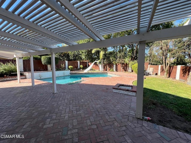 view of pool featuring a yard, a patio, a water slide, and a pergola