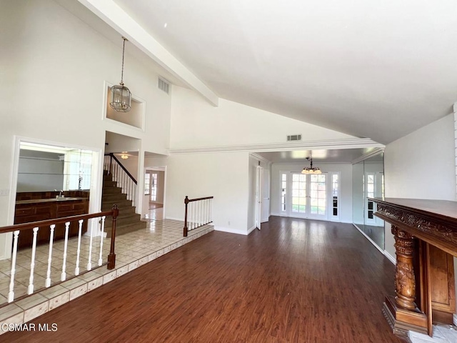 living room with vaulted ceiling with beams, dark hardwood / wood-style flooring, and a chandelier