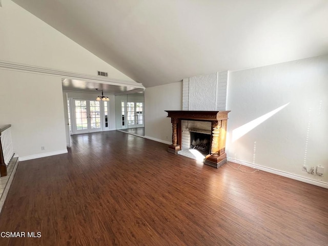 unfurnished living room featuring french doors, a fireplace, dark hardwood / wood-style flooring, and vaulted ceiling