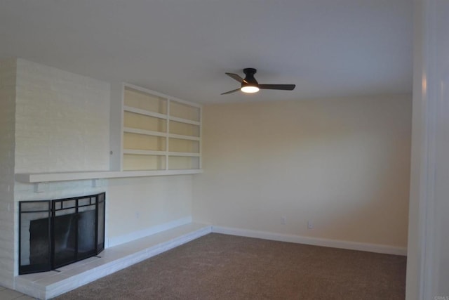 unfurnished living room featuring ceiling fan, carpet flooring, built in features, and a fireplace