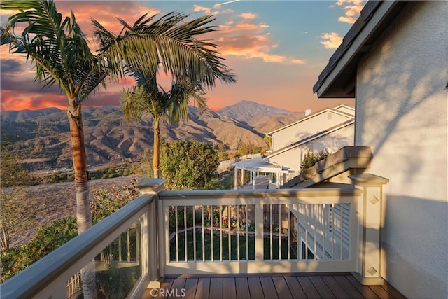 deck at dusk featuring a mountain view