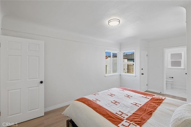 bedroom featuring ensuite bathroom and light hardwood / wood-style floors