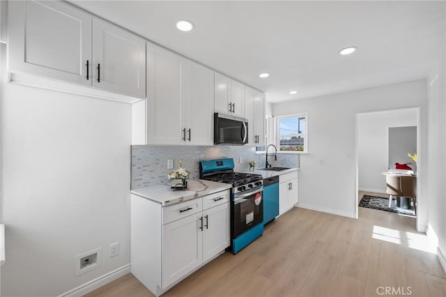 kitchen with appliances with stainless steel finishes, backsplash, white cabinetry, and sink