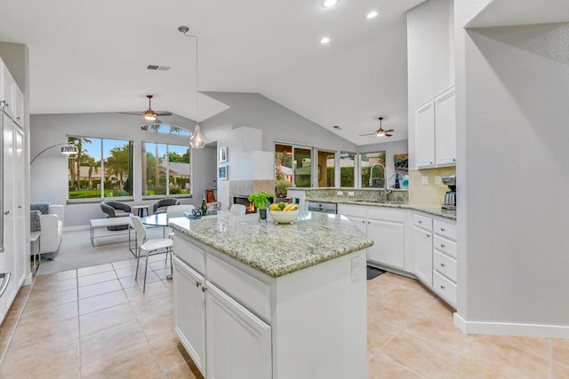 kitchen featuring sink, white cabinetry, vaulted ceiling, and a kitchen island