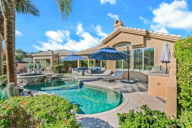 view of swimming pool featuring exterior kitchen, outdoor lounge area, a patio, and an in ground hot tub