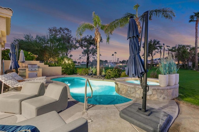 pool at dusk with a patio area, area for grilling, and an in ground hot tub